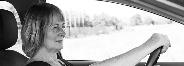 Woman using a bluetooth hearing aid connection in her car
