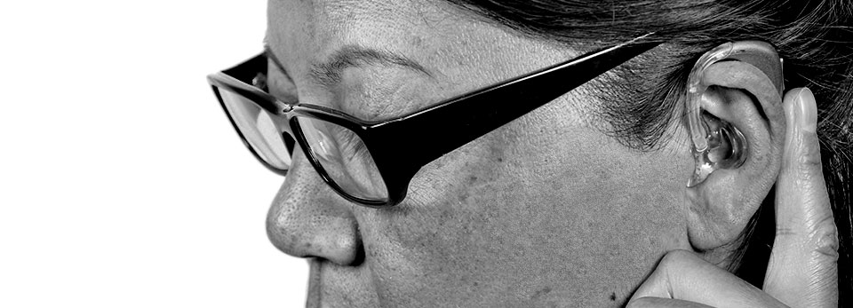 Woman adjusting her hearing aid