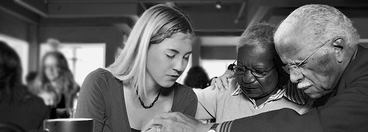An older couple and a young girl pray together